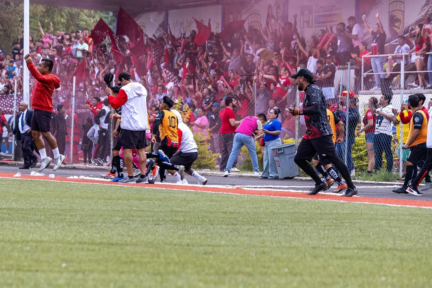 Jugadores, cuerpo técnico y afición de Dragones corren a festejar el ascenso junto a la tribuna.