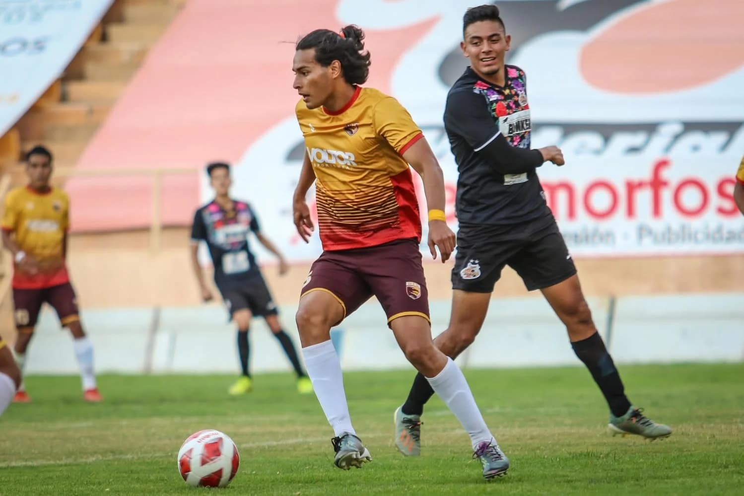 Un jugador de Dragones conduce el balón perseguido por un rival en el Estadio ITO.